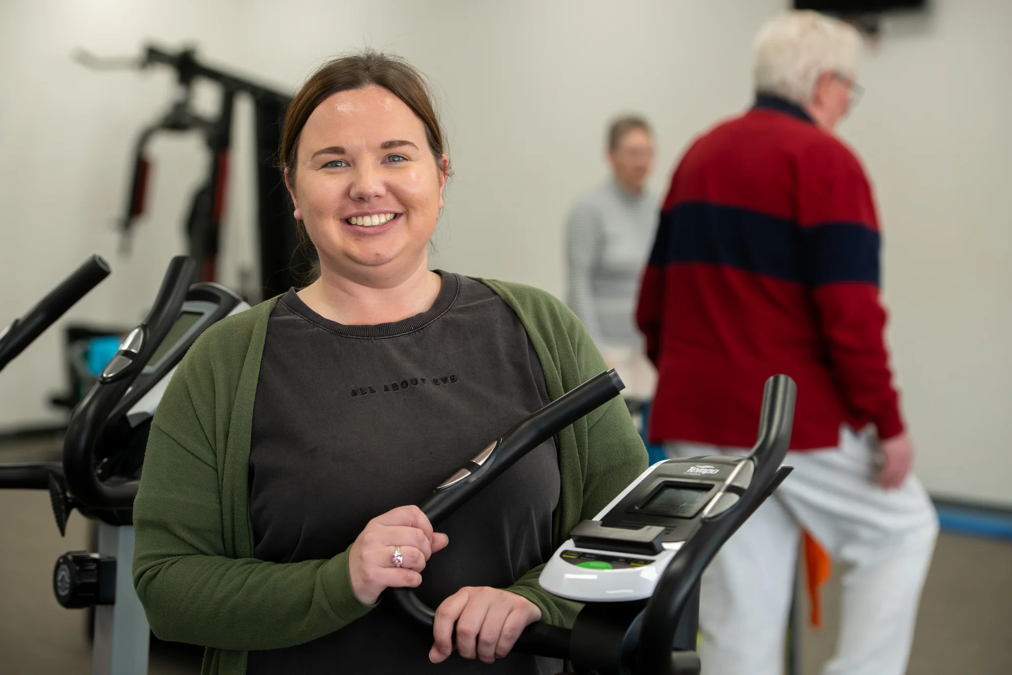 Women in front of a treadmill, smiling